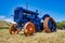 Blue agricultural truck with orange wheels on a grassy field in Otaki in New Zealand