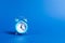 A blue alarm clock on a blue background. Limited offer and over time. Planning and discipline. waiting for a meeting. Punctuality