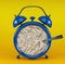 Blue alarm clock with porridge concept on yellow background