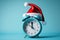 blue alarm clock with a red Christmas hat on it, blue background. Generative AI