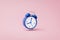 Blue alarm clock ringing on pink background with rush hour concept. Notification to wake up time or work. 3D rendering