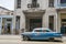Blue american car under a Cuba sign