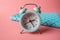 Blue analog metal alarm clock on stylish blue-pink background. Concept of time in pastel colors