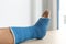 Blue ankle and foot splint Bandages on the legs from a young man`s fall accident