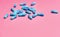 Blue antibiotic capsule pills on pink background. Blue antibiotic capsules spread on pink background with space for text.