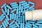 Blue antibiotic capsule pills texture with white bottle. Pharmaceutical production. Global health. Resistance to antibiotic drugs