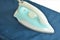 Blue automatic electric iron pressing cloth on ironing board