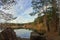 Blue autumn sky with clouds reflected in the pond