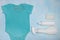 Blue baby bodysuit with stains and different types of stain removers. Dirty clothes. Stubborn stains. Clean linen. Loss of color.