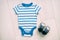 Blue baby boy clothes top view on background texture with grey shoes. Stripes onesie outfit clothing layed out on table