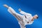 On a blue background athlete beats roundhouse kick