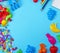 Blue background with childrens plastic toys, pencils, balloons a