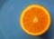 Blue background with fruit citrus an orange or half  tangerine. Macro image and close-up, concept for healthy food.
