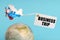 On a blue background, a globe and an airplane with a sign - Business trip
