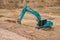 Blue backhoe excavating soil and sand