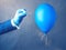 Blue balloon. Man hold needle directed to air balloon.