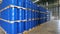 Blue barrel 200 liter chemical drums are stacked on wooden pallets inside the warehouse awaiting delivery. Concept of Chemical