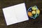 Blue basket with Easter eggs on a dark brown wooden background, unfolded notebook for copy space