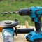 A blue battery drill stands on a wooden table in the garden. Electtroinstructs. Repair