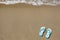Blue beach slippers on sandy beach with copy space