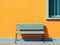 a blue bench against an orange wall