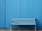 a blue bench sitting in front of a blue wall