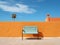 a blue bench sitting in front of an orange wall
