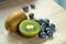 Blue berries or blueberries and kiwi fruit bunches on the desk wood background of bright colors are naturally nutritious and fresh