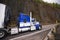 Blue big rig semi truck transporting refrigeration semi trailer