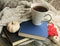 Blue and black books in pile with coffee mug and blanket