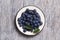 Blue blackthorn berries in metallic bowl on a table