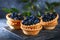 Blue blackthorn berries in sand tartlets on a table.
