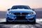 Blue bmw m3 sportcar without logos in mountain road. Frontal view