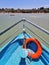 A blue boat sailing in the bay sea towards the beach. Inside View from the front of the boat.