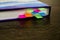 A blue book with colored bookmarks on a wooden table