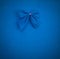 Blue bow on a blue background with vignette. mock up for text, congratulations, phrases