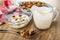 Blue bowl with cereal, napkin, cereal breakfast with chocolate and caramel in bowl with yogurt, pitcher with yogurt, spoon on