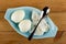 Blue bowl with egg shells, boiled eggs, spoon on wooden table. Top view