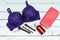 Blue bra with brush and bottle perfume, pink clutch bag