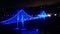 Blue bridge shines light in the dark at night