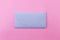 Blue bright envelope on a pastel pink background.