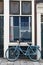 Blue bycicle in front of window