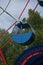 Blue cabin of the round shaped Ferris wheel against the background of the blue sky.