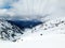 Blue cable cars flying over ski slope mountains Eastern Pyrenees, Andorra, sunny winter day