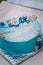 Blue cake with mastic cross and angels for boy christening party.