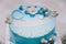 Blue cake with mastic cross and angels for boy christening party.