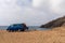 Blue camper van parked on a rocky beach on the wild coast of Andalusia