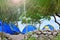 Blue camping tents stand in the green rainforest by the sea