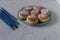 Blue candles and traditional Hanukkah food doughnuts with sugar powder sufganiyot on a grey concrete background