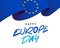 Blue canvas of the European flag with 12 yellow stars flutters in the wind. Stylish lettering - Happy Europe Day